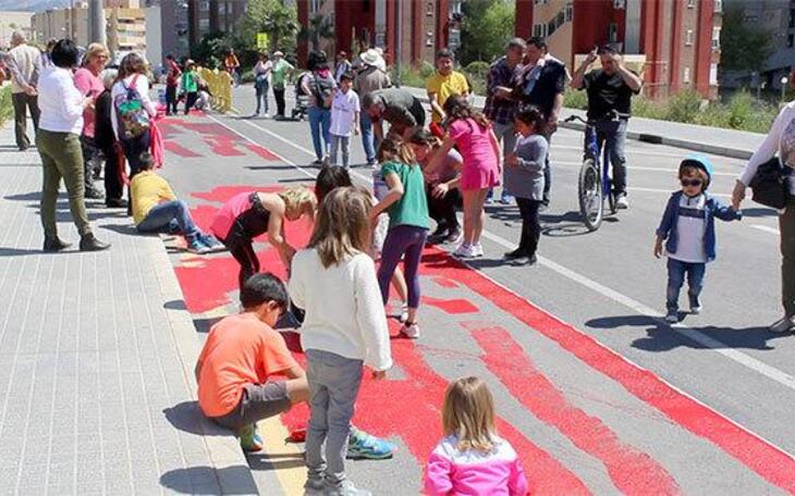 Los niños de Els Tolls pintan de rojo el nuevo carril bici en un día de fiesta y convivencia vecinal